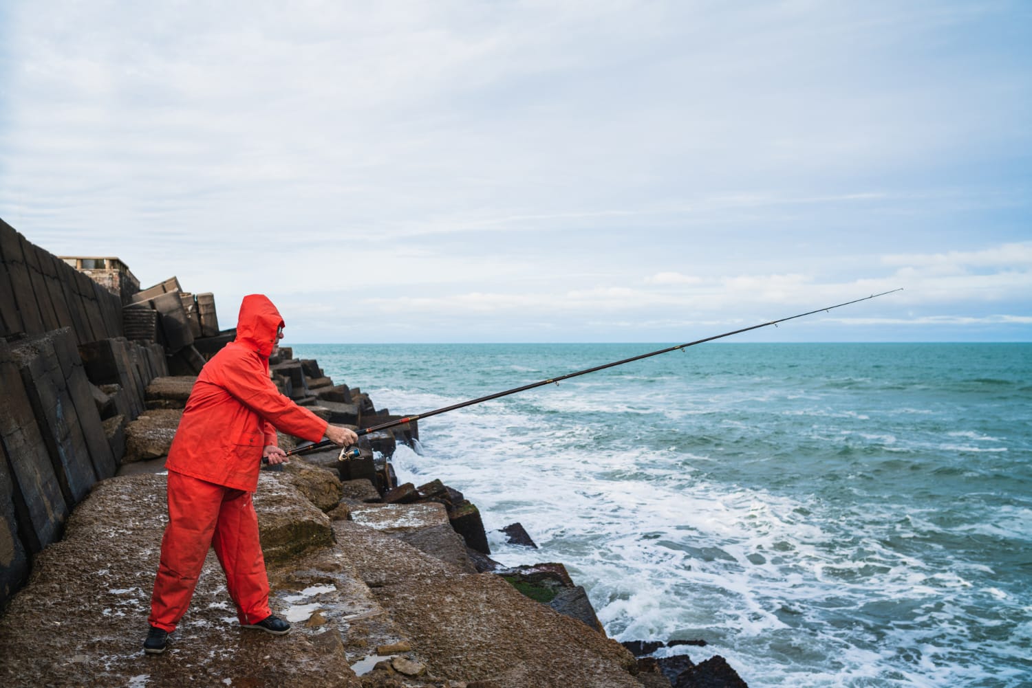 homem pescando na pedra